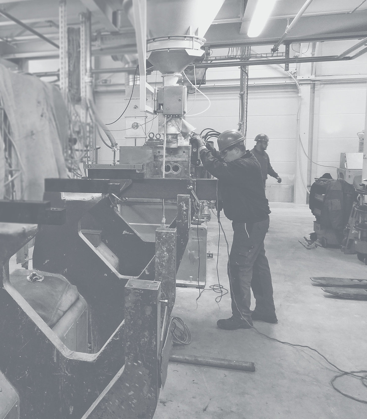 The service of Extruder Experts accompanies its customers along the entire process chain. Employee in a workshop operates a machine