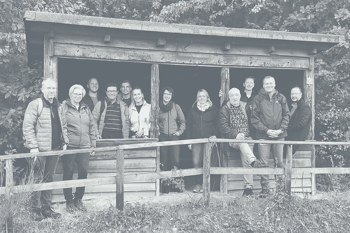 Photo de groupe des employés d´ Extruder-Experts devant une cabane en bois