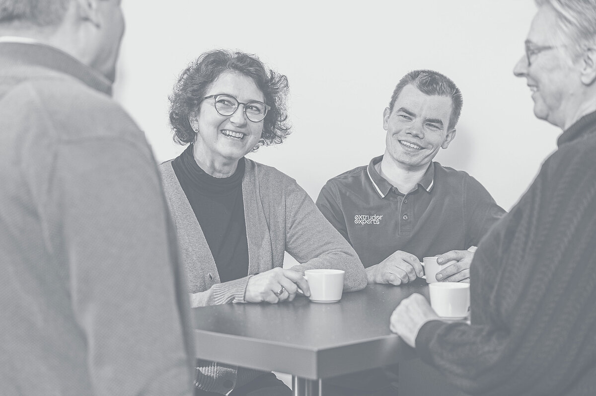Four people sit together at the table during the lunch break