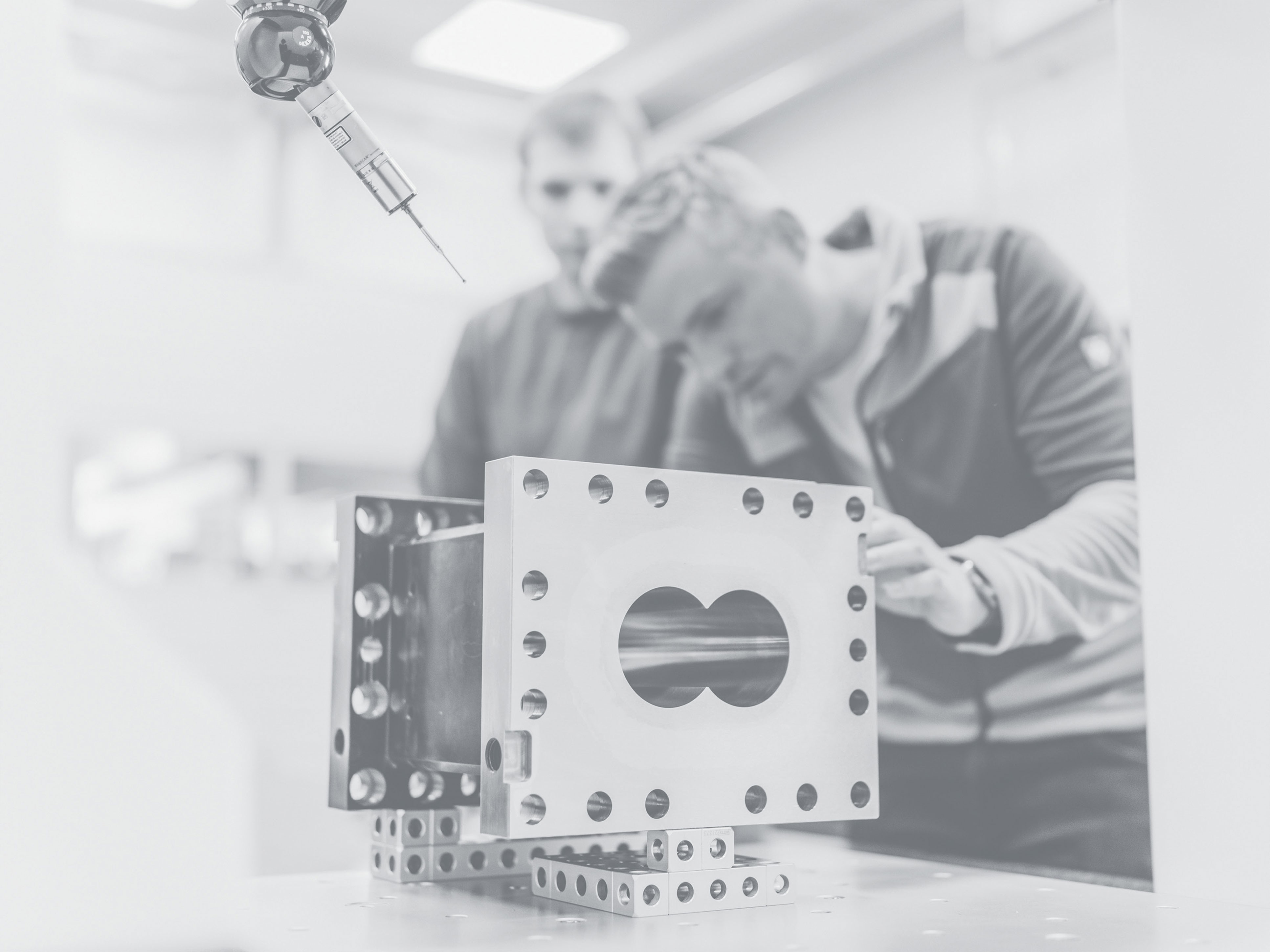 Un dipendente di Extruder Experts lavora con un laser su un alloggiamento.
